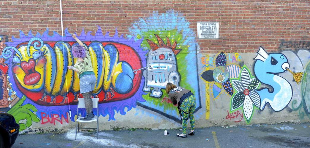Artists work to convert graffiti to mural on Trade Street in WinstonSalem