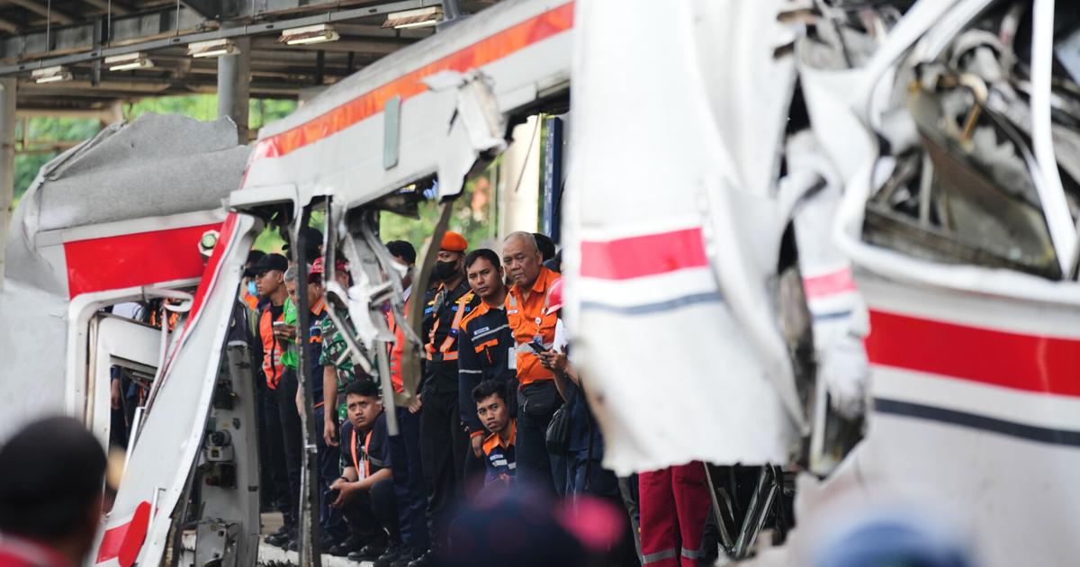 Penyelamat mengeluarkan korban dari kecelakaan kereta api di Indonesia, dalam foto