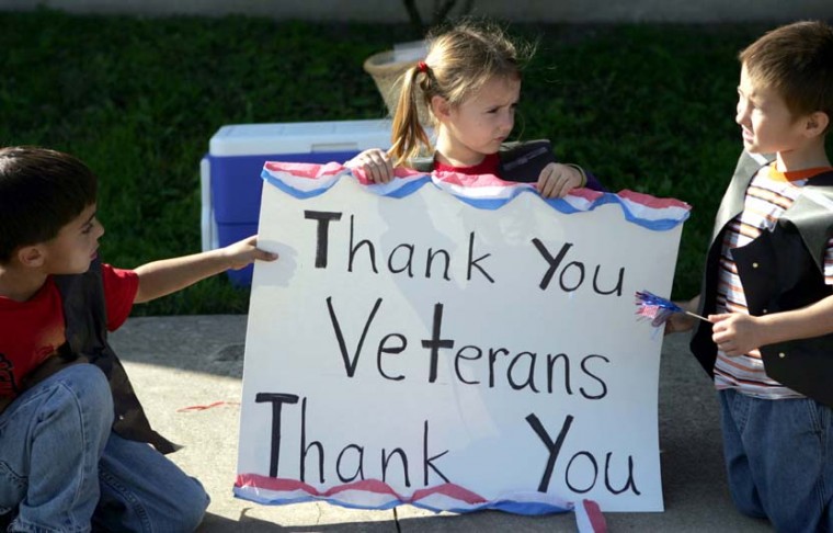 Kindergarteners hold up a sign