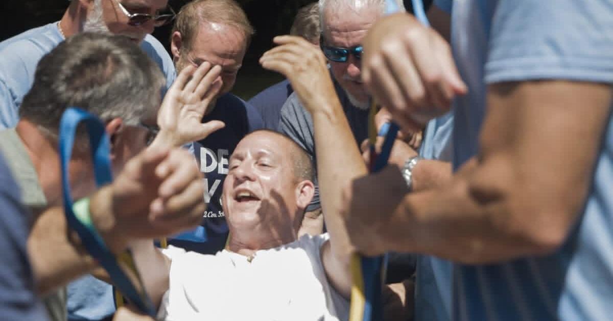 An emotional baptism for new believer who was paralyzed