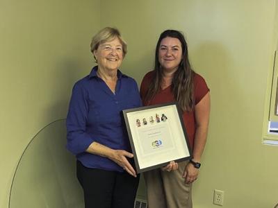 Diane Gubatayao, left, holds her award from the Alaska Children's Trust