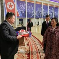 This picture released by North Korea's official Korean Central News Agency (KCNA) on August 30, 2025 shows Kim Jong Un handing over a portrait wrapped in a flag to the family of a soldier