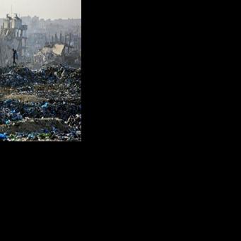 A Palestinian boy searches for recyclable material at a landfill against the backdrop of destroyed buildings in Khan Yunis, in the southern Gaza Strip on January 25, 2026. Since October 10, a fragile US-sponsored truce in Gaza has largely halted the…