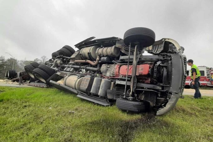 Truck overturns spilling a large load of lumber across the highway ...