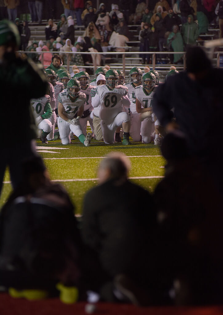 The Blair Oaks High School football team takes a knee and watches