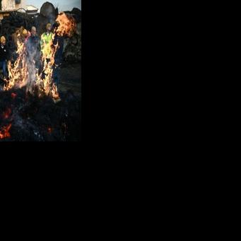 Farmers of the CR47 union stand by a bonfire during a proteset in southwestern France