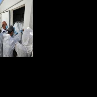 Morgue workers unload the bodies of Palestinians that had been in Israeli custody, after they were transported by Red Crescent vehicles and refrigerated trucks to Khan Yunis in the Gaza Strip