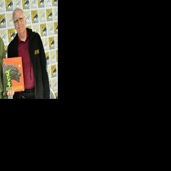 Authors Steve Ryfle (L) and Ed Godziszewski pose with a copy of their book about the first 70 years of the "Godzilla" franchise