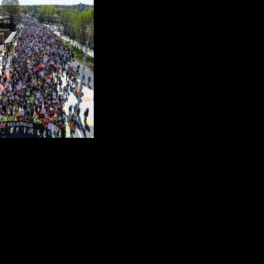 People hold banners, signs and flags as they march near the Georgia state Capitol building in Atlanta