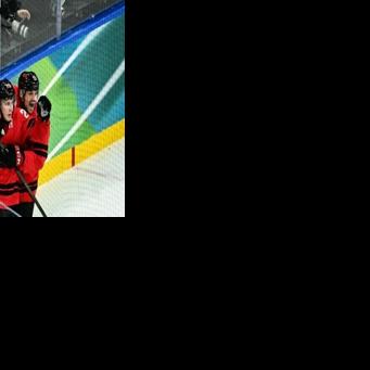 Nathan MacKinnon (L) celebrates scoring Canada's late winner over Finland at the 2026 Winter Olympics