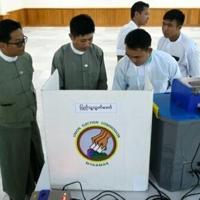 Members of Myanmar's Union Election Commission demonstrate a voting machine during the UEC's first major press conference in Naypyidaw on September 11, 2025
