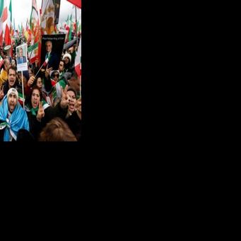 Iranian demonstrators hold flags and posters depicting Iran's former crown prince and now key opposition figure Reza Pahlavi in Munich