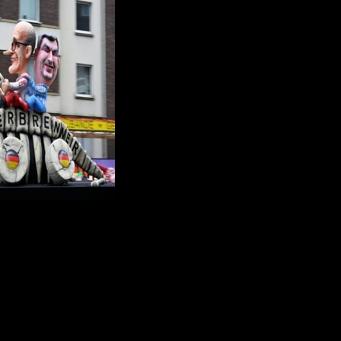 Effigies of German Chancellor Friedrich Merz (L) and Bavarian leader Markus Soeder driving a skeleton marked 'combustion engine' for weakening car pollution laws