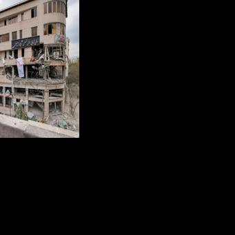 A woman surveys damage to a Tehran building that housed the offices of Qatari news network Al Araby TV following a missile strike