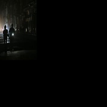 People walk on a street without power during a nationwide blackout in Havana on March 21, 2026