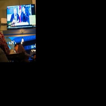 Residents watch a press conference of Greenland's Foreign Minister Vivian Motzfeldt and Denmark's Foreign Minister Lars Loekke Rasmussen in Nuuk after a meeting over the future of the island held in Washington