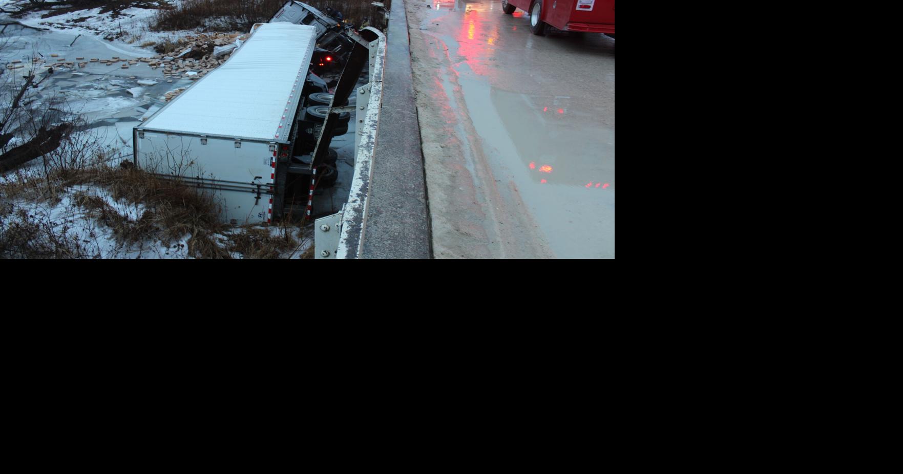 Semi lands in creek after sliding off bridge; temporarily closing