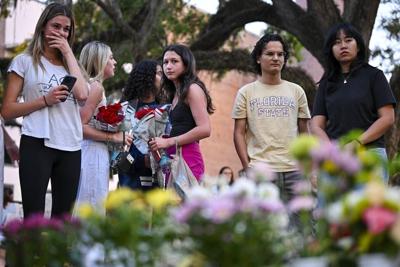 Students hold a vigil near the scene of a shooting at Florida State University. The gunman allegedly consulted ChatGPT about how to carry out the attack.