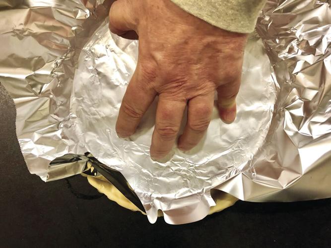 Lining the tart with foil.