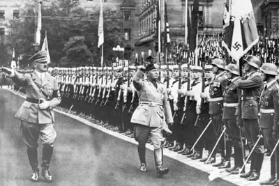 Hitler and Mussolini salute Nazi troops in 1937. Bettmann/Getty Images