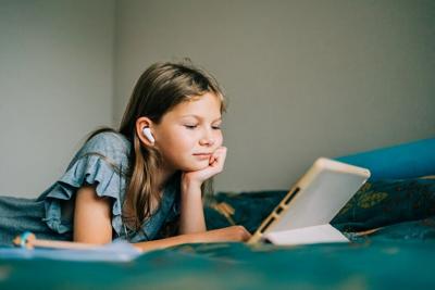 Her earbuds are connected to her tablet by radio waves.