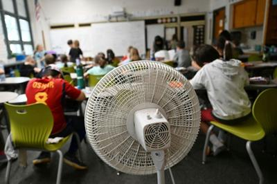 Many older school buildings lack air conditioning, leaving fans as the main defense against classroom heat.