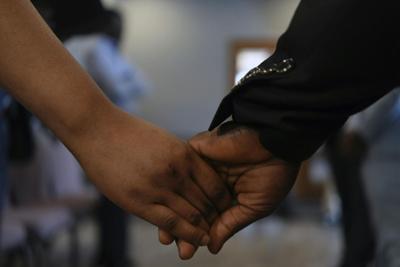 Ushers at the First Haitian Evangelical Church of Springfield, Ohio, hold hands during Sunday service on Jan. 26, 2025.