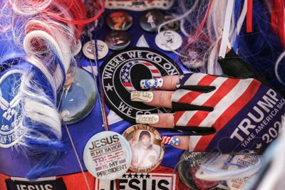 A woman touches a QAnon patch on her outfit during a Christian prayer gathering in Washington on May 17, 2026.