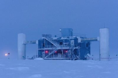 The Moon rises behind the IceCube Neutrino Observatory at the South Pole.