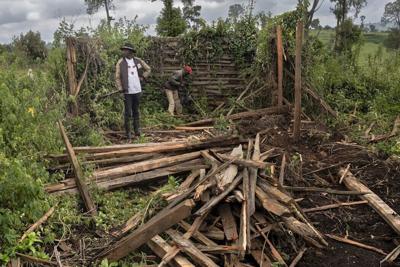 Fred Ngusilo, left, a member of the Ogiek community, works with a relative to sift through the ruins of their grandfather's house in the Mau forest, destroyed by Kenyan police.