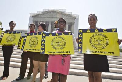 Representatives from the NAACP stand outside the Supreme Court on June 25, 2013, awaiting a decision in Shelby County v. Holder.