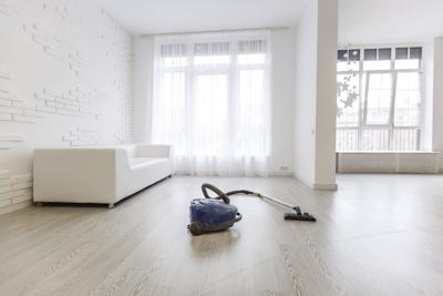 Vacuum cleaner on white concrete background in the house.