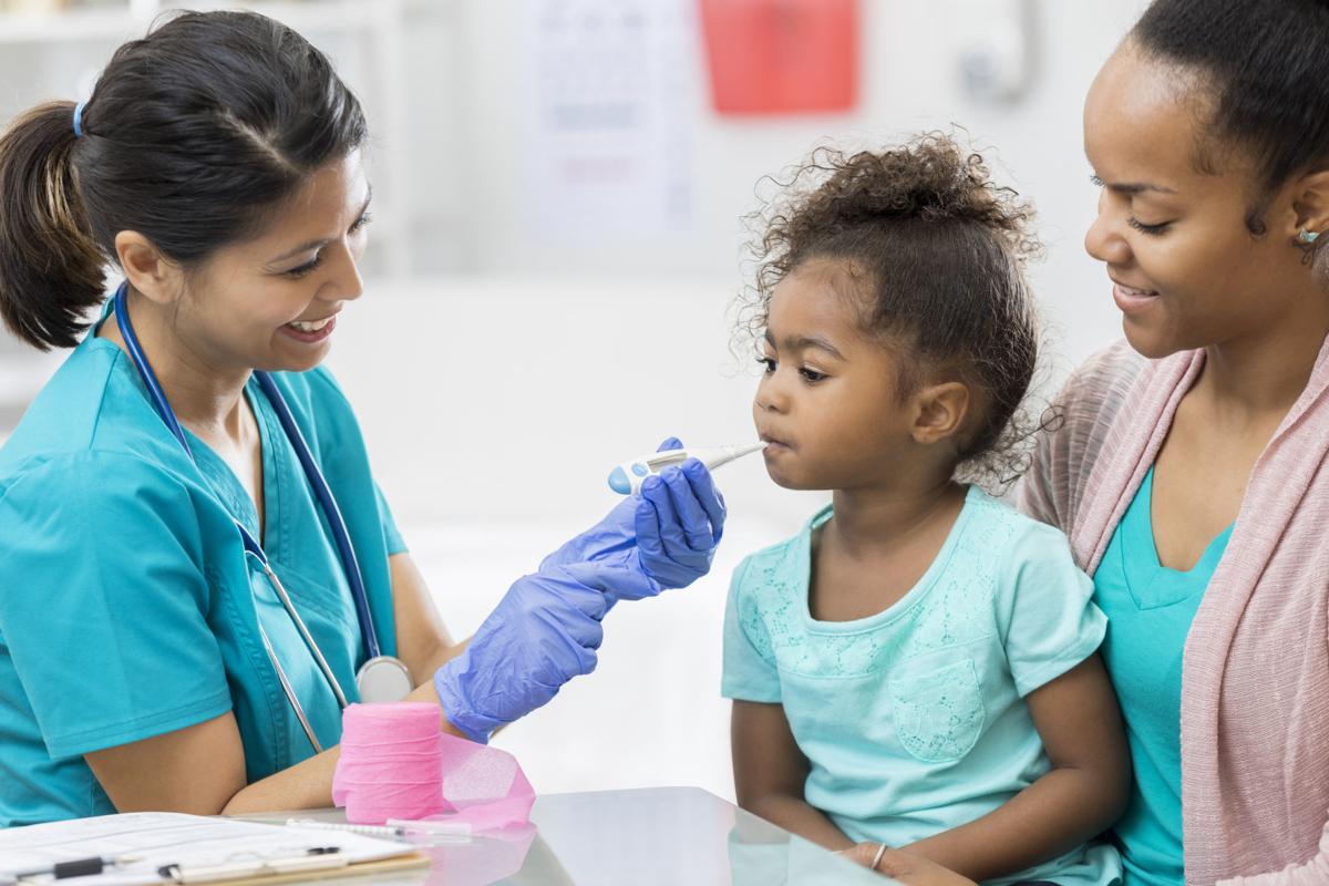 Nurse checks preschool age girl's temperature