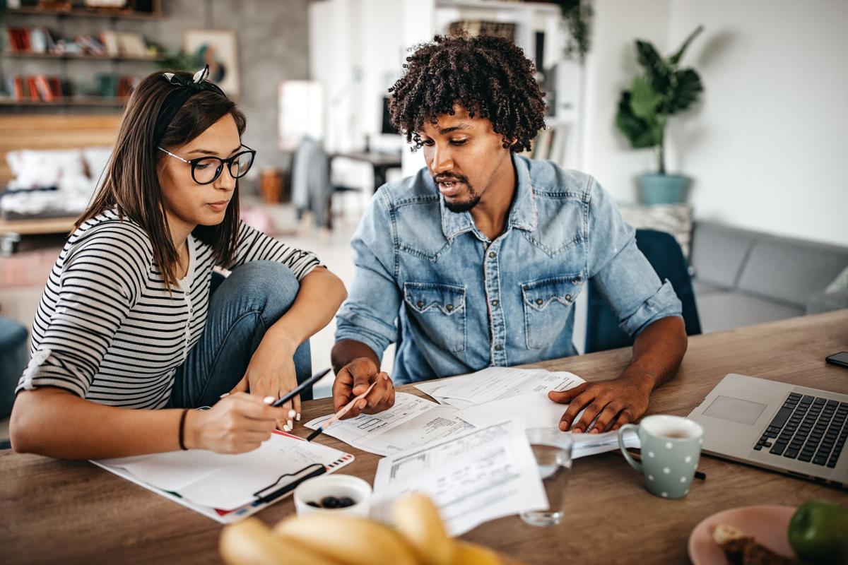 Multi-ethnic couple planning their home budget