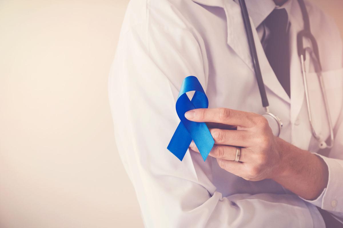 Doctor hands holding blue ribbon, diabetes and Colorectal Cancer Awareness