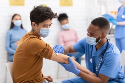 Asian Man Receiving Coronavirus Vaccine Injection During Appointment In Hospital