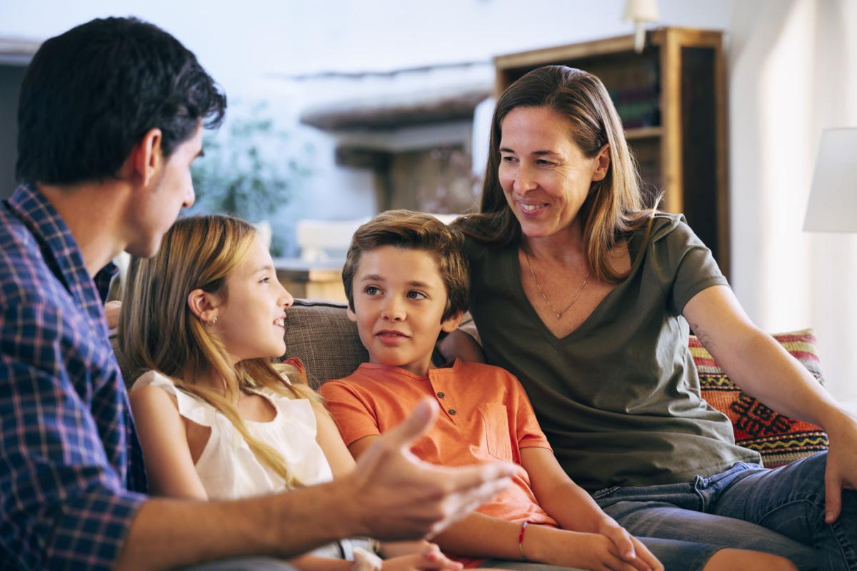 Young Spanish family together on sofa in family home