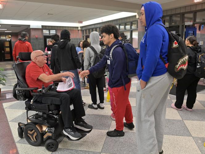 Brother Frank Albrecht greets students as they enter McCaskey East for