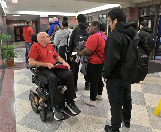 Brother Frank Albrecht greets students as they enter McCaskey East for