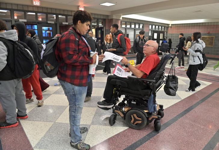 Brother Frank Albrecht greets students as they enter McCaskey East for