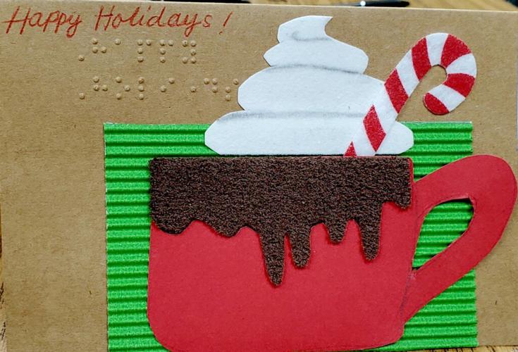 Student designing braille greeting cards for visually impaired Local