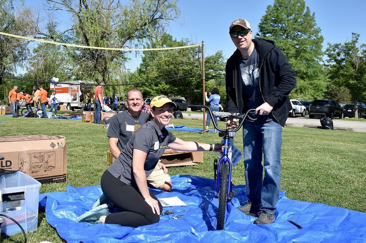 Volunteers assemble bikes for children in need during