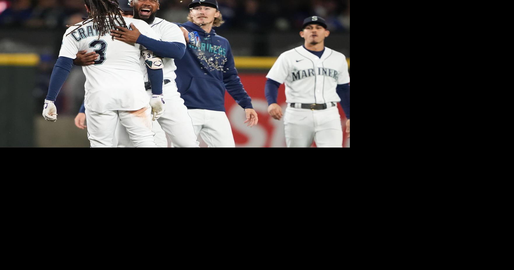 Seattle Mariners' Teoscar Hernandez holds a trident in the dugout