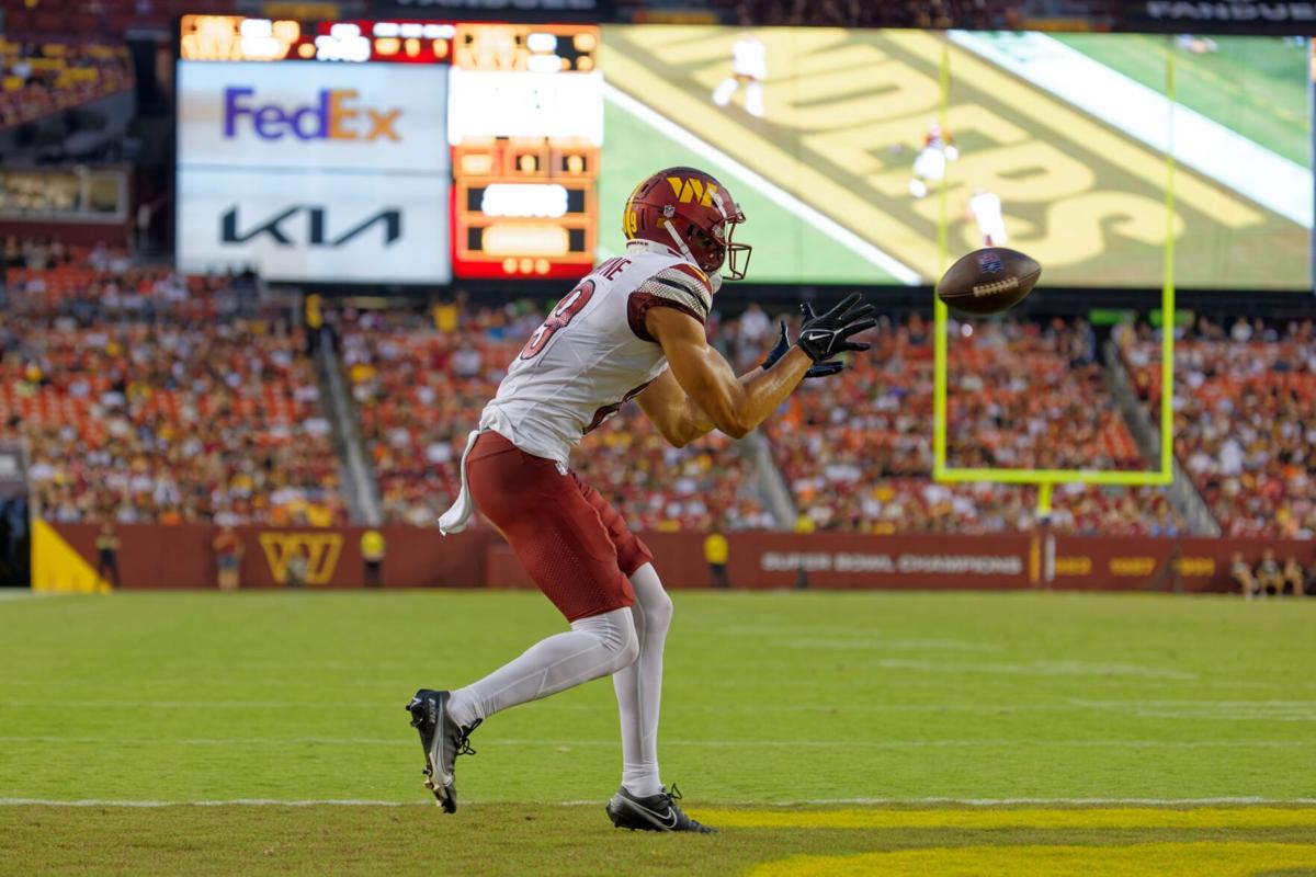 Washington Commanders wide receiver Mitchell Tinsley (86), left,  celebrating his touchdown against the Cincinnati Bengals with teammate  Marcus Kemp (19) and others during the first half of an NFL preseason  football game