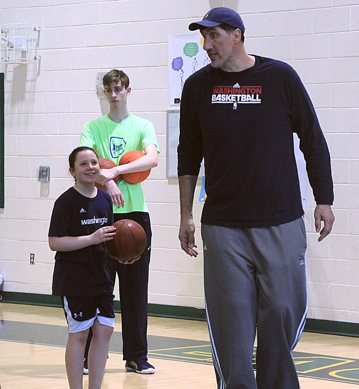 Former NBA player Gheorghe Muresan tosses a basketball to a child