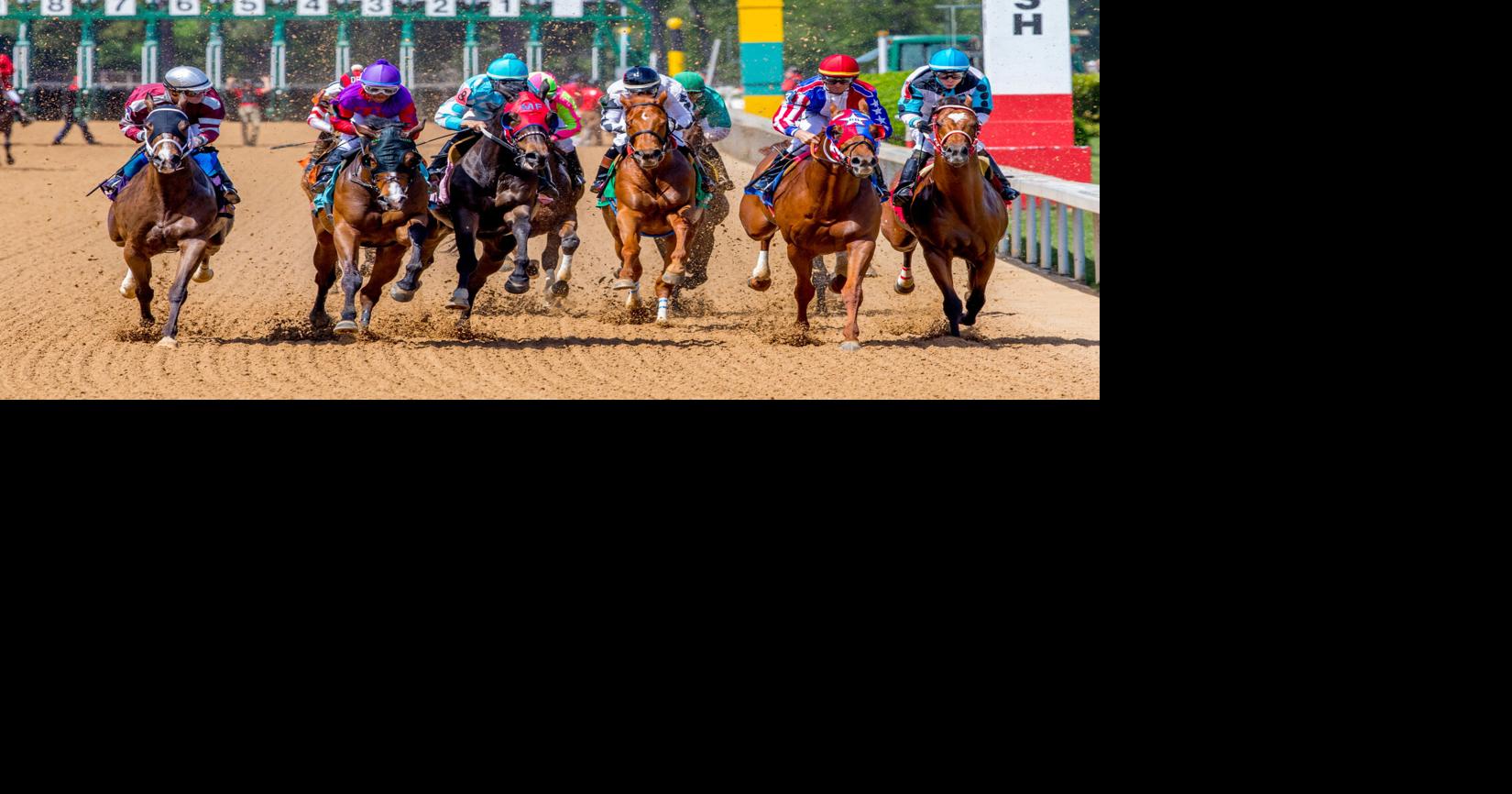 horses and their jockeys racing around the track at Oaklawn