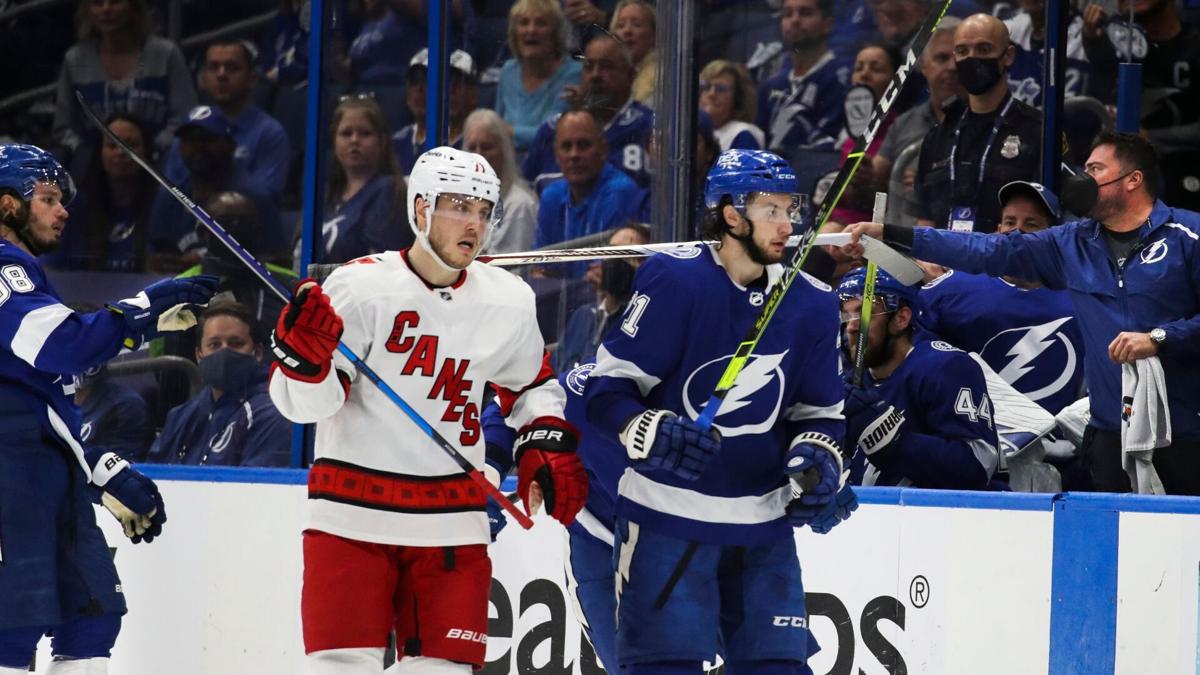 Lightning defenseman Mikhail Sergachev, in background on left, gets handed a stick after his broke while on the ice against the Hurricanes in the first period of Game 3 in Tampa.