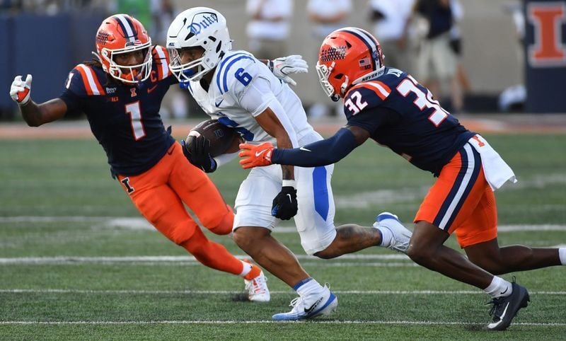 Sep 12, 2026; Champaign, Illinois, USA;  Duke Blue Devils wide receiver Jonah Burton (6) runs the ball past Illinois Fighting Illini defensive back Xavier Scott (1) and defensive back Tywan Cox (32) during the second half at Gies Memorial Stadium.  Mand...