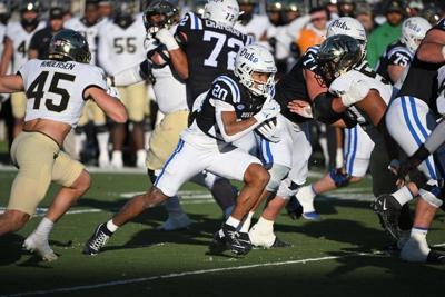 Nov 29, 2025; Durham, North Carolina, USA; Duke Blue Devils running back Nate Sheppard (20) runs the ball past Wake Forest Demon Deacons defensive back Nick Andersen (45) during the first quarter at Wallace Wade Stadium. Mandatory Credit: Zachary Taft-I...