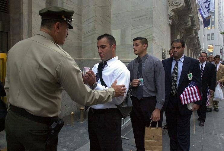 A security guard at the New York Stock Exchange checks employees on Sept. 17, 2001, for proper identification as they wait to enter the building. Wall Street and the stock exchanges reopened after the 9/11 terrorist attacks.